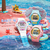 Three colorful digital watches on a beach-themed background with 'BABY-G' branding.