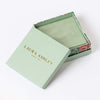 Laura Ashley green gift box with a rose inside on a white background